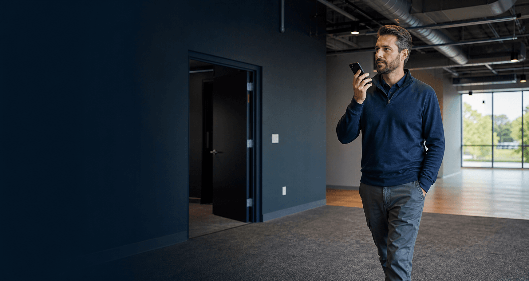 Field-service estimator speaking observations into a phone during a commercial property walkthrough
